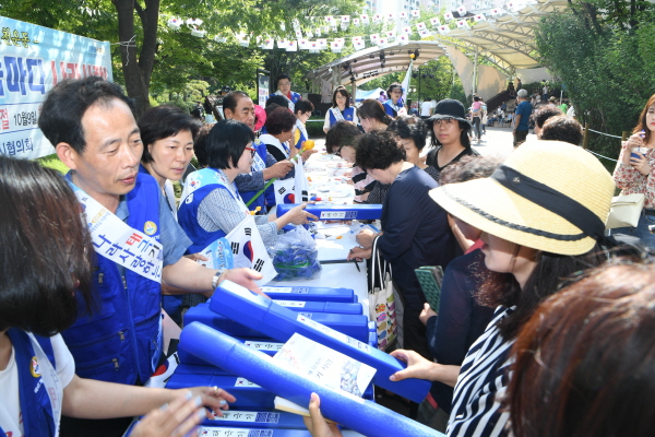 바르게살기운동 구리시협의회 회원들이 제3회 장자못축제 기간 중 태극기 달기 서명 운동과 태극기를 무료로 배부하고 있다.