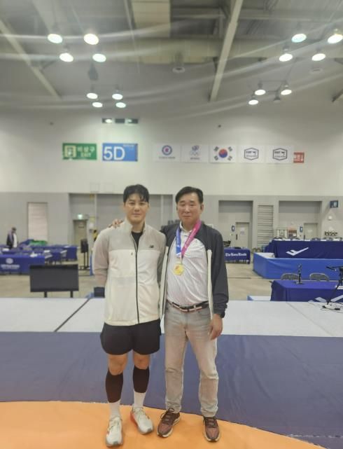 레슬링부 윤창희 감독과 김현우 선수가 기념사진을 찍고 있다.