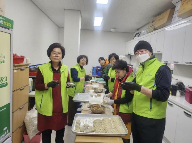 인창동 행정복지센터에서 인창동 지역사회보장협의체 위원들이 독거노인을 위한 떡만둣국 전달식을 진행하고 있다.