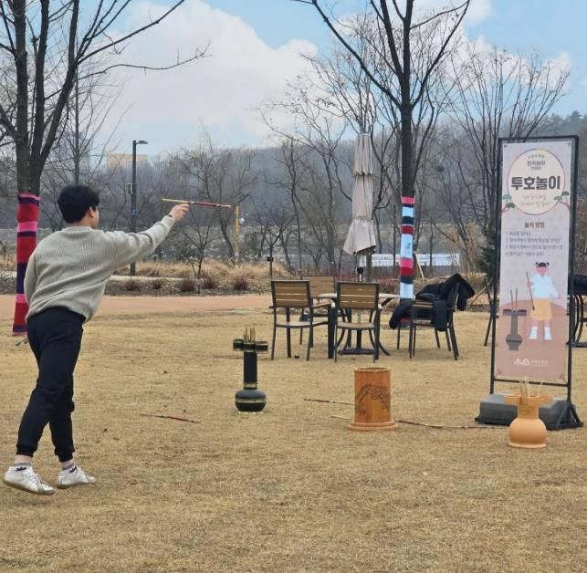 한 시민이 수목원에 마련된 투호놀이 체험존에서 전통놀이를 즐기고 있다