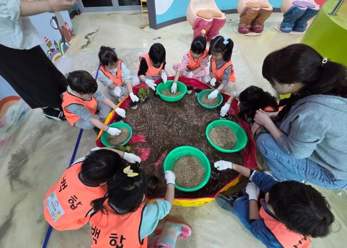 상추화분을 만들고 있는 중동백합어린이집 어린이들