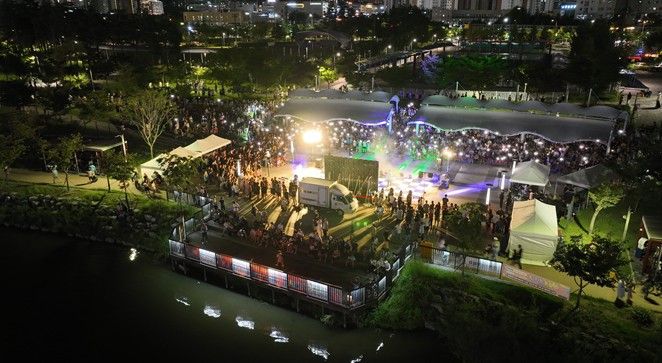 미사호수공원 계단광장을 가득 메운 시민들이 자유로운 분위기 속에서 버스킹 공연을 관람하며 일상의 즐거움을 만끽하고 있다. 사진은 2025년 하반기 오픈 공연 현장